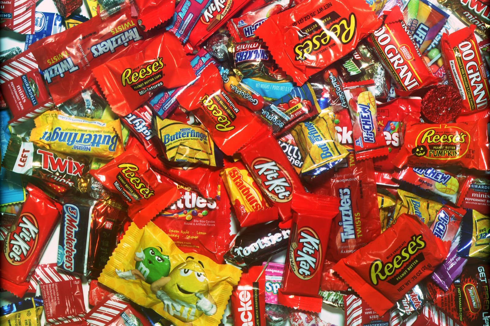 A pile of wrapped fun-size Halloween candy: peanut butter cups, wafer bars, chocolate bars, licorice twists, fruit chews and peppermints